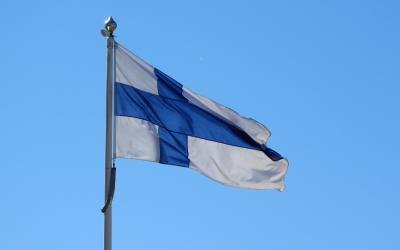 Suomen lippu heiluu sinistä taivasta vasten