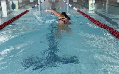 nainen ui vapaauintia uimahallin altaassa
