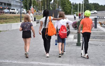 Neljä lasta kulkee yhdessä Uudenkaupungin kaupunginlahden rannalla.