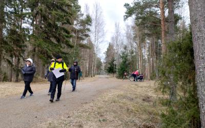 Kävelijöitä Käätyjärven reitillä, ihmisiä ja leveä sorapolku metsän siimeksessä.