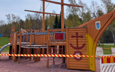 Puinen iso lasten kiipeilyleikkilaiva, jonka ympärille vedetty huomionauha laivan maalaustöitä varten.