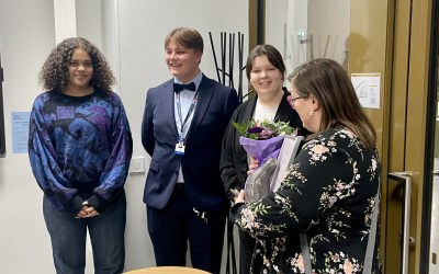 kolme nuorta onnittelee naakka kiertopalkinnon saanutta naista