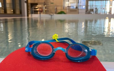 Uimahallissa altaan reunalla uimalasit uimapatjan päällä