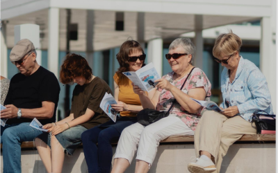 ikäihmiset istuu ulkona laulamassa