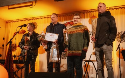 Ihmiisä rivissä valaistulla lavalla.