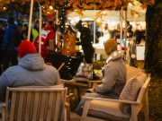 Höyrysaunan esittelypiste, jossa ihmiset saunatakit päällä.