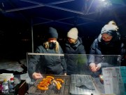 kolme naista paistaa makkaraa