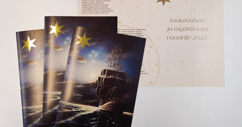 Uudenkaupungin Merihistoriallisen yhdistyksen joulukortti 2022, kuvassa vene öisessä meressä ja iso kultainen tähti