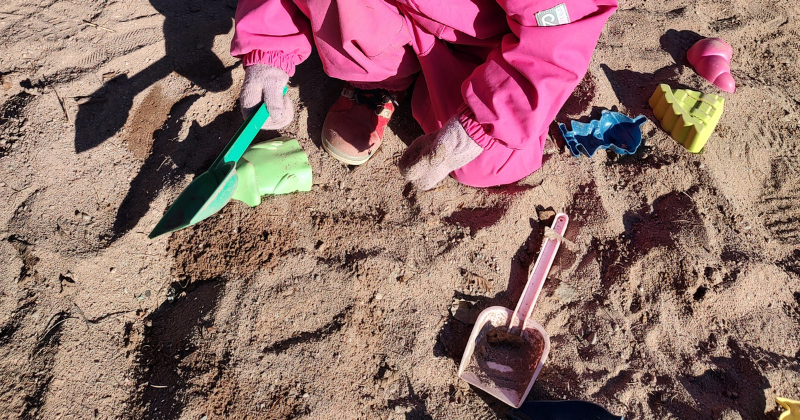 Lapsi leikkii hiekkaleluilla
