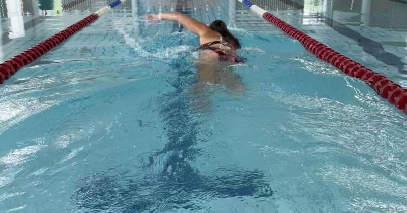 nainen ui vapaauintia uimahallin altaassa