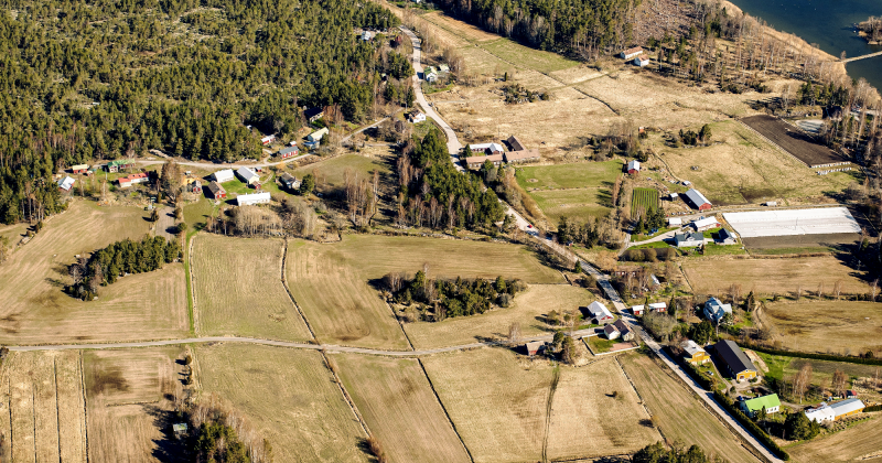 Ilmakuva Kettelin kylämiljööstä. Kuvassa näkyy metsää, peltoa, vähän merta, sekä erilaisia taloja ja piharakennuksia.