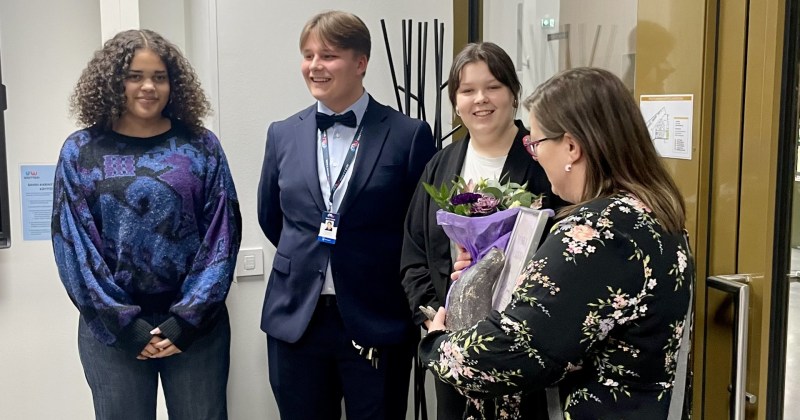 kolme nuorta onnittelee naakka kiertopalkinnon saanutta naista