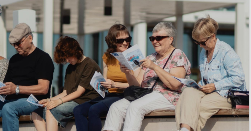 ikäihmiset istuu ulkona laulamassa