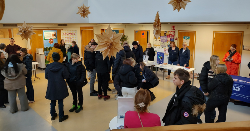 Nuoria sisätiloissa keskustelemassa eri ihmisten kanssa.