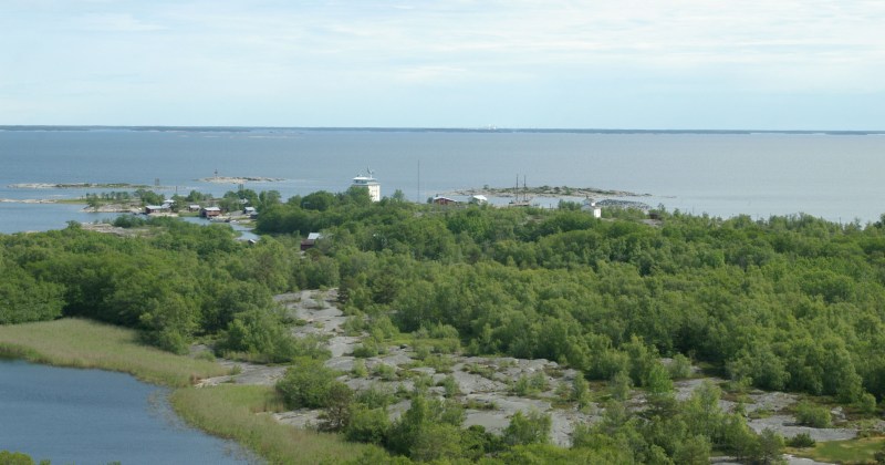 Kuva Isokarin majakkasaarelta, kuvassa vettä ja etualalla saari, rakennuksia ja laiva.