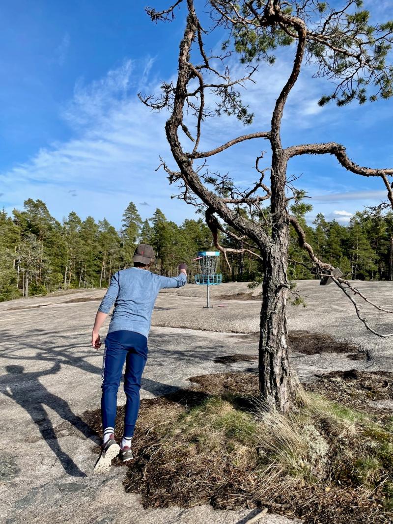 poika heittää friebeetä etualalla käkkyrämänty ja kalliota