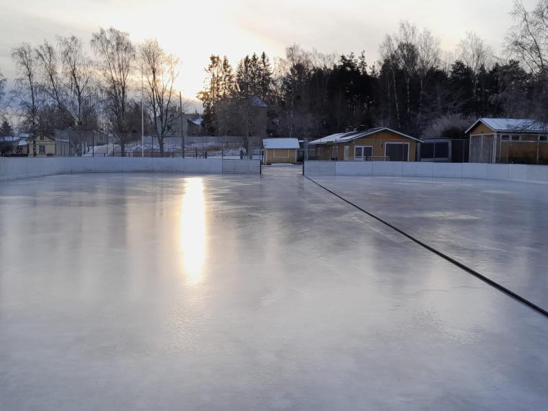 luistelukenttä, jonka taustalla huoltorakennukset ja puita