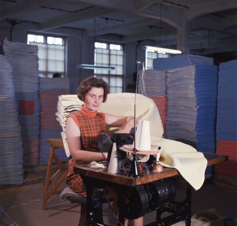 Nainen ompelee ompelukoneella.